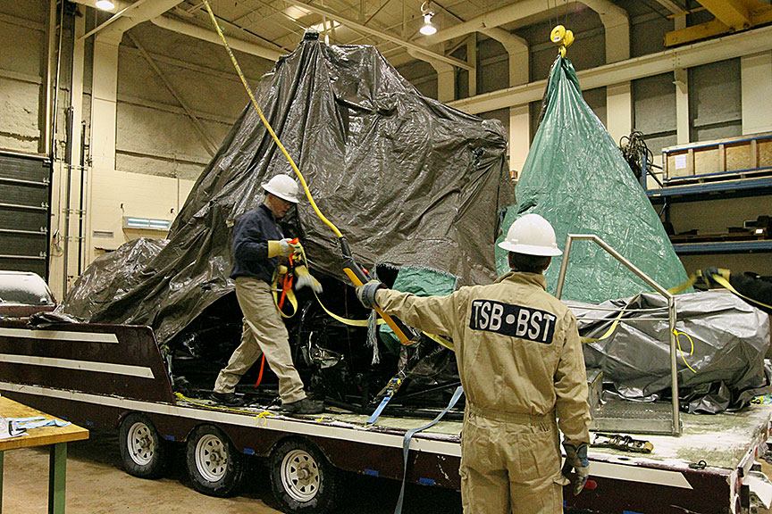 TSB staff uncovering helicopter wreckage on trailer